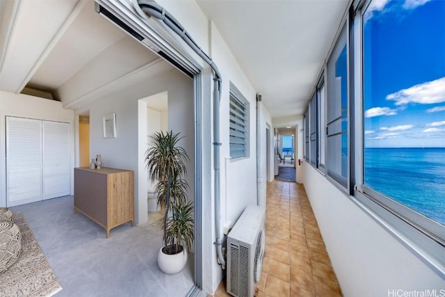 hallway with light tile patterned flooring and a water view