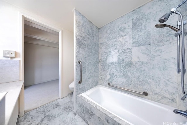 bathroom with tiled shower / bath combo and toilet