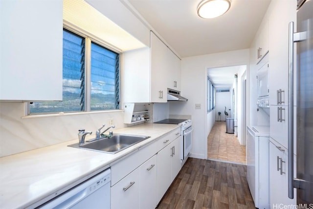 kitchen with white appliances, dark hardwood / wood-style floors, sink, and white cabinets