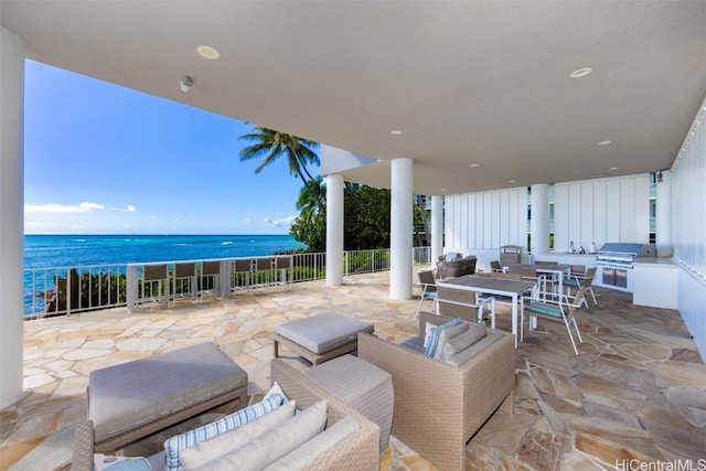 view of patio featuring a water view, grilling area, and exterior kitchen