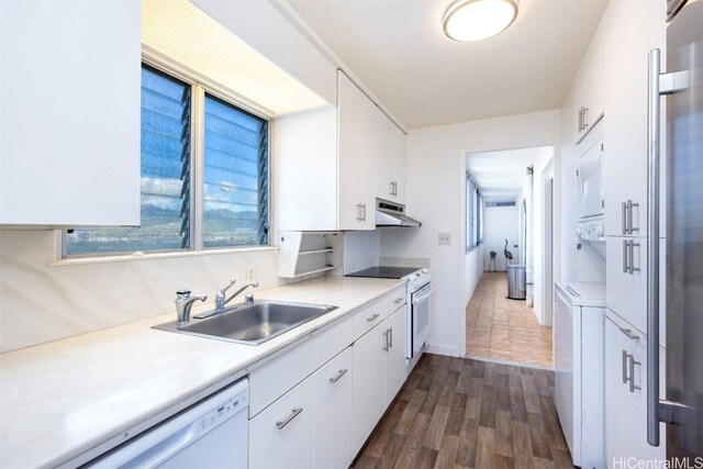 kitchen featuring dark wood-type flooring, sink, dishwasher, wall oven, and white cabinets