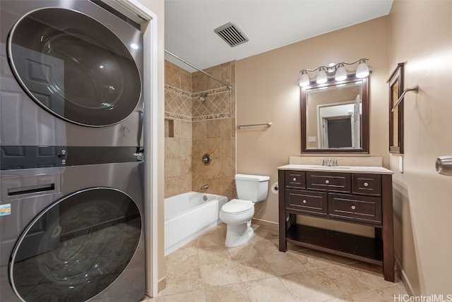 full bathroom with tiled shower / bath combo, vanity, stacked washer and clothes dryer, and toilet