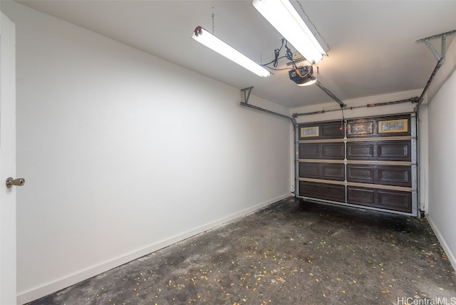 garage featuring a garage door opener and baseboards