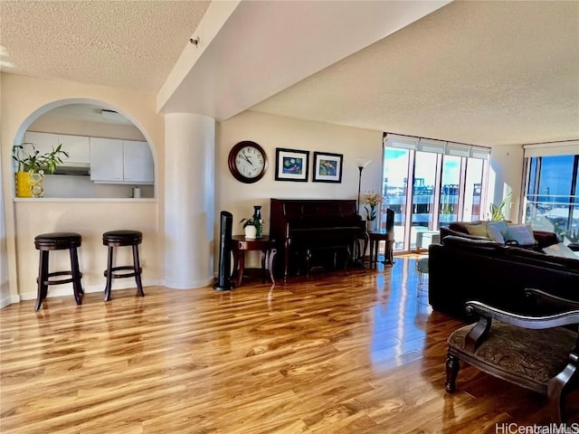 misc room with expansive windows, a textured ceiling, and light wood-type flooring