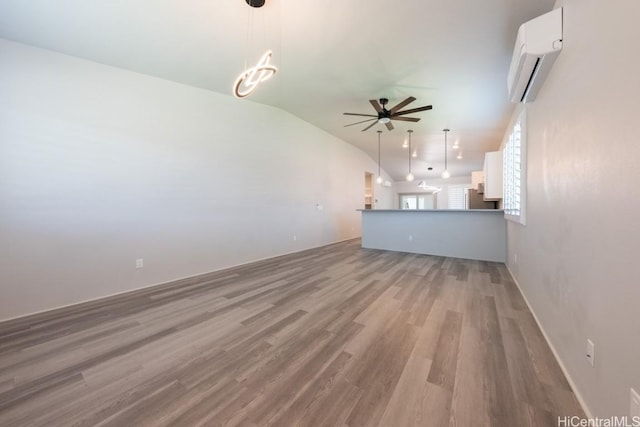 unfurnished living room with wood-type flooring, lofted ceiling, ceiling fan, and a wall unit AC