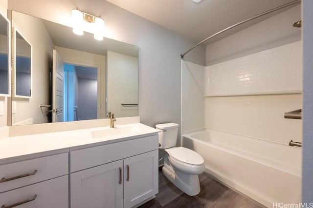 full bathroom featuring hardwood / wood-style flooring, tiled shower / bath, vanity, and toilet