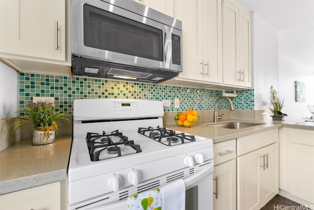 kitchen with sink, white gas stove, and backsplash