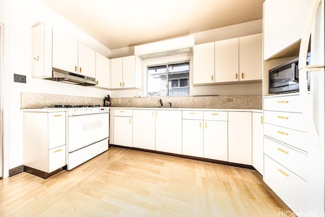 kitchen featuring sink, gas range gas stove, black microwave, light hardwood / wood-style floors, and white cabinets