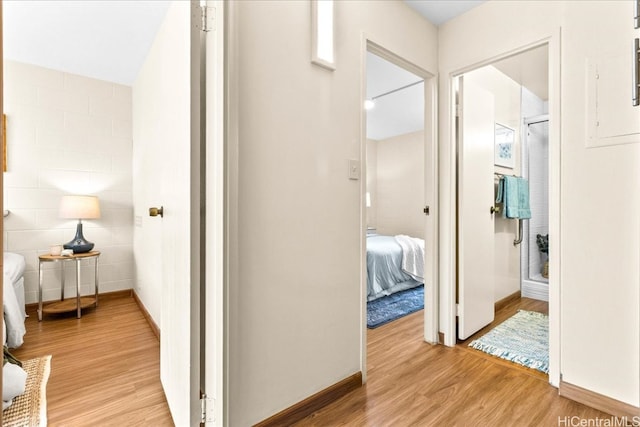 hall featuring light wood-style floors and baseboards