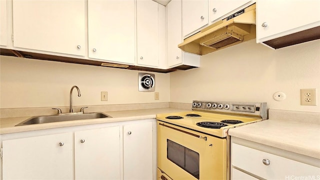 kitchen featuring sink, range with electric stovetop, and white cabinets