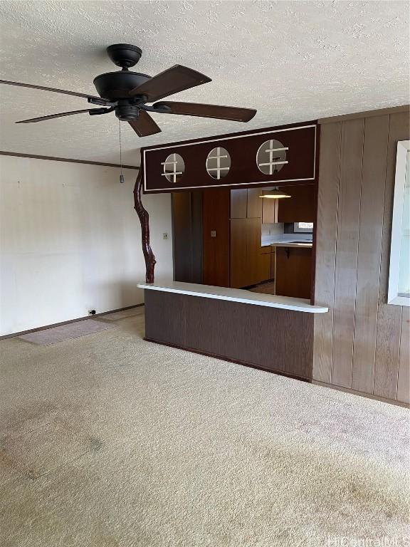 unfurnished living room with ceiling fan, light carpet, and a textured ceiling