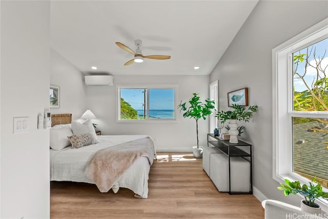 bedroom featuring light wood finished floors, baseboards, a ceiling fan, a wall mounted AC, and recessed lighting