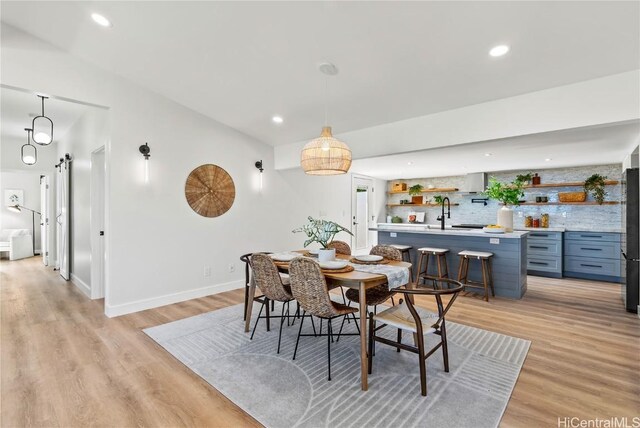 dining area featuring recessed lighting, baseboards, and light wood finished floors