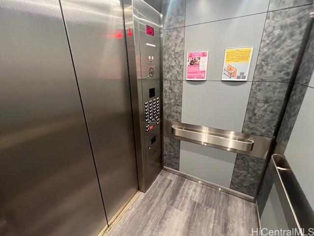 interior details with elevator and hardwood / wood-style floors