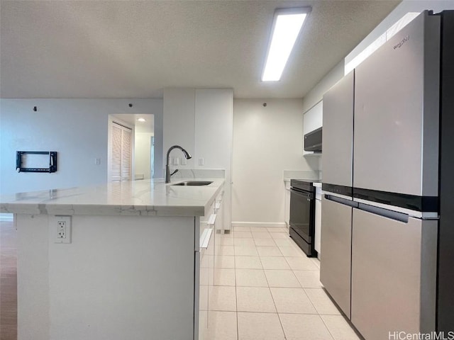 kitchen featuring stainless steel refrigerator, white cabinetry, sink, electric range, and kitchen peninsula