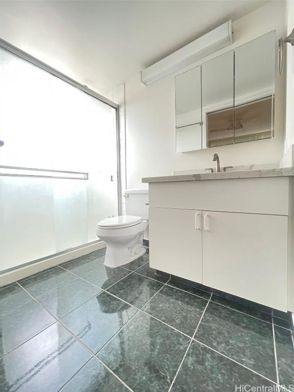 bathroom featuring walk in shower, tile patterned floors, vanity, and toilet