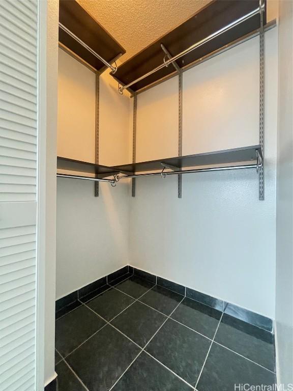 spacious closet with dark tile patterned floors