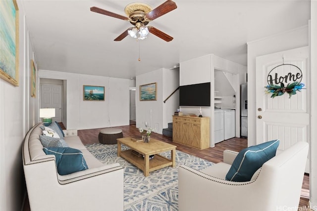 living room with wood-type flooring, washing machine and dryer, and ceiling fan