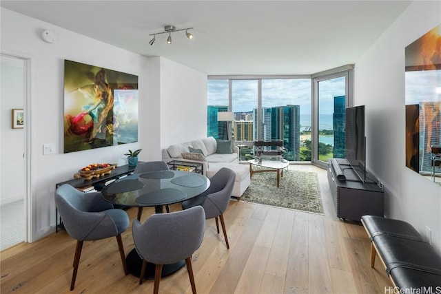 dining room featuring floor to ceiling windows and light hardwood / wood-style floors