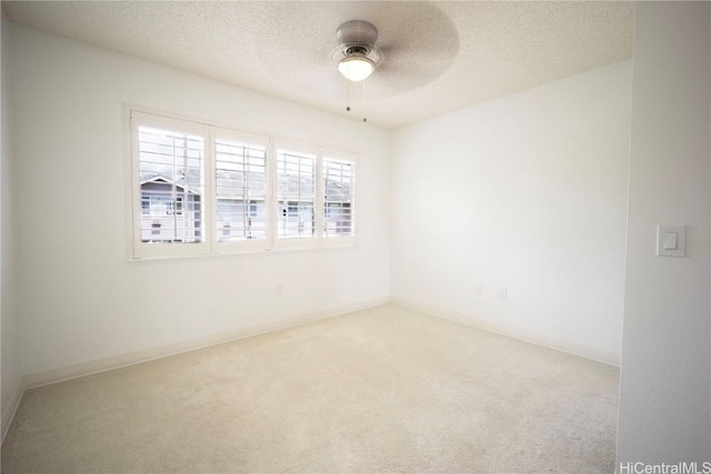 carpeted spare room featuring ceiling fan and a textured ceiling