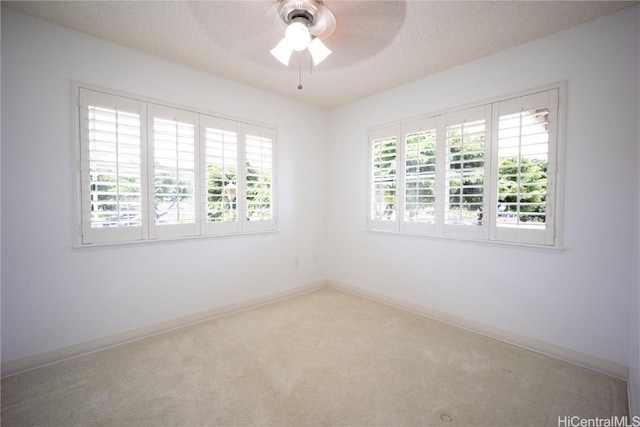 carpeted spare room with ceiling fan and a textured ceiling