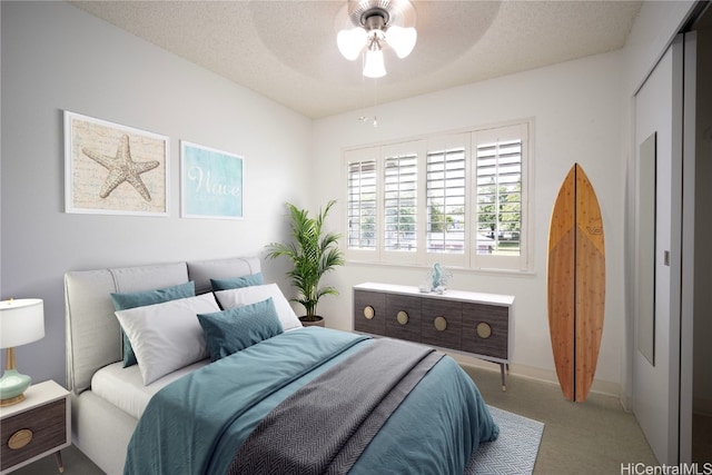 bedroom with ceiling fan, carpet floors, and a textured ceiling