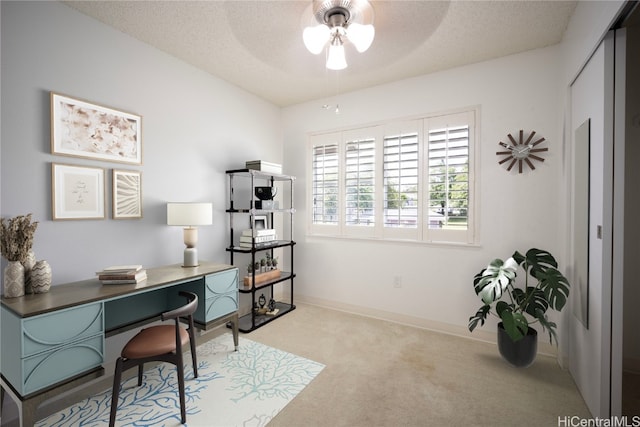 office area with ceiling fan, light colored carpet, and a textured ceiling