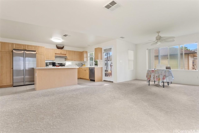 kitchen featuring visible vents, light countertops, appliances with stainless steel finishes, light brown cabinets, and under cabinet range hood