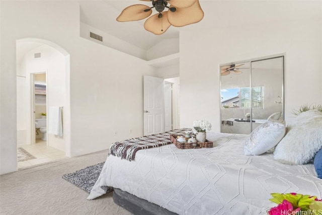 carpeted bedroom featuring arched walkways, a closet, visible vents, and ceiling fan