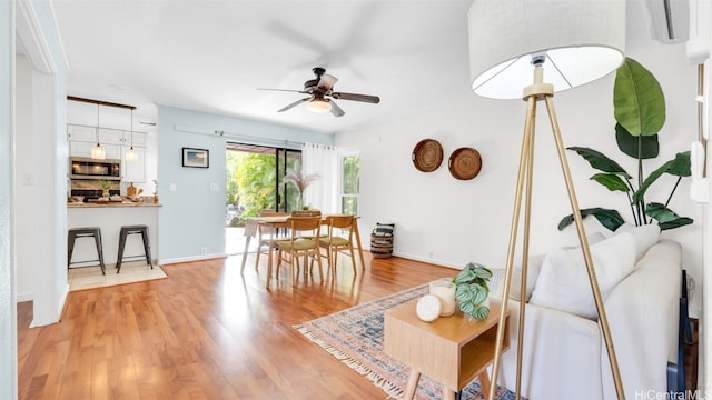 living room with ceiling fan and light hardwood / wood-style flooring