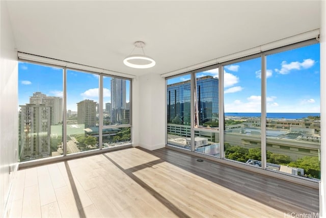 unfurnished sunroom with a view of city and a water view