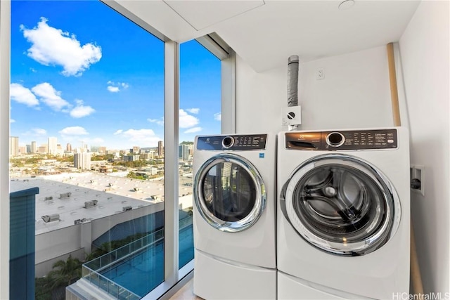 laundry room featuring separate washer and dryer and a city view