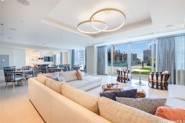 living area with a healthy amount of sunlight, floor to ceiling windows, and a tray ceiling