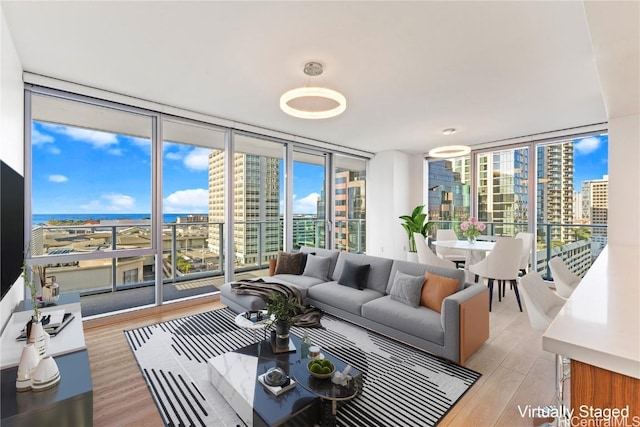 living room with expansive windows, light hardwood / wood-style floors, and a wealth of natural light