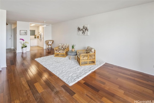 living area with dark hardwood / wood-style flooring and ceiling fan