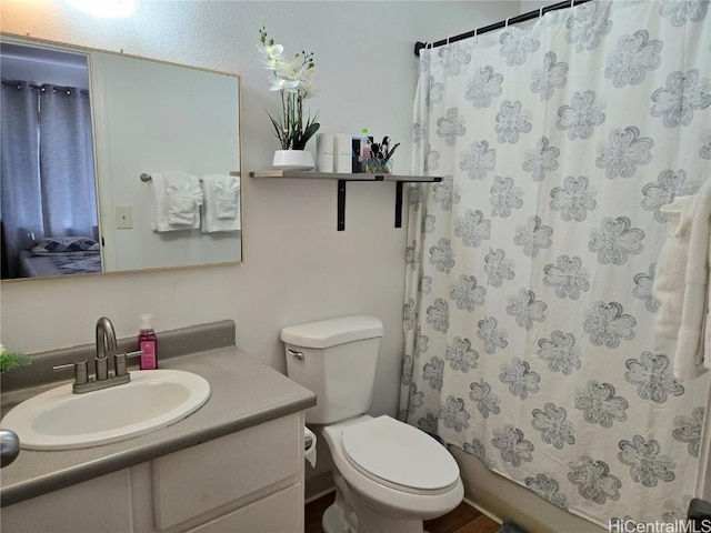 bathroom featuring vanity, toilet, and curtained shower