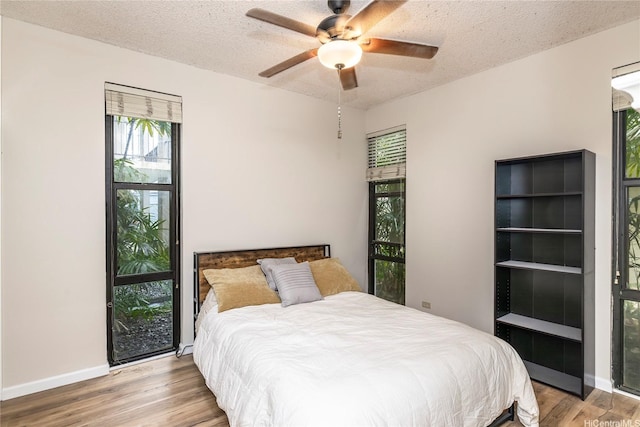 1020 Aoloa Pl Unit 109B, Kailua, HI 96734 - bedroom with light wood-style flooring, baseboards, a textured ceiling, and ceiling fan