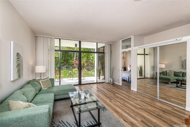 1020 Aoloa Pl Unit 109B, Kailua, HI 96734 - living room featuring a wall of windows, wood finished floors, and a textured ceiling