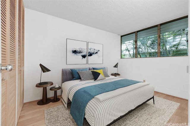 bedroom featuring a textured ceiling and light wood finished floors