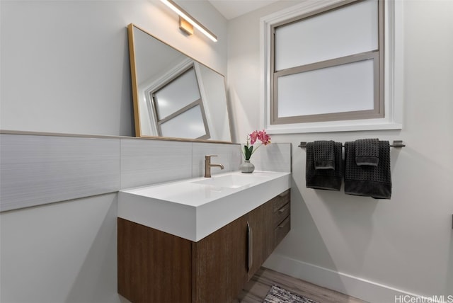 bathroom with tasteful backsplash, vanity, and hardwood / wood-style floors