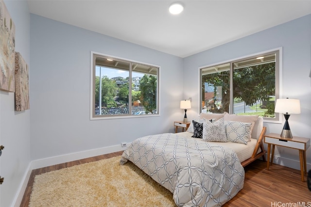 bedroom featuring hardwood / wood-style flooring and multiple windows