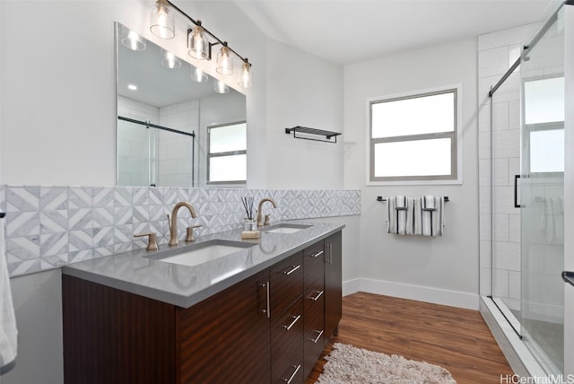 bathroom with vanity, decorative backsplash, a shower with door, and hardwood / wood-style flooring