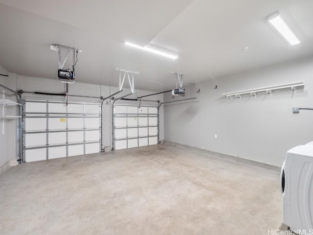 garage featuring a garage door opener and washer / dryer