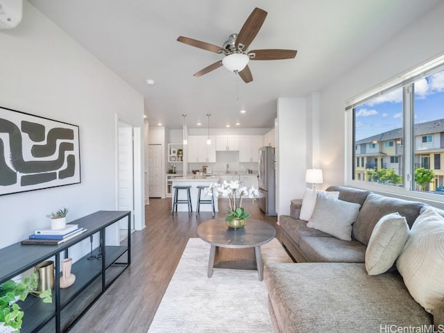 living room featuring ceiling fan and light hardwood / wood-style floors