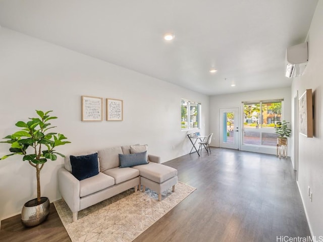 living room featuring hardwood / wood-style flooring and a wall unit AC