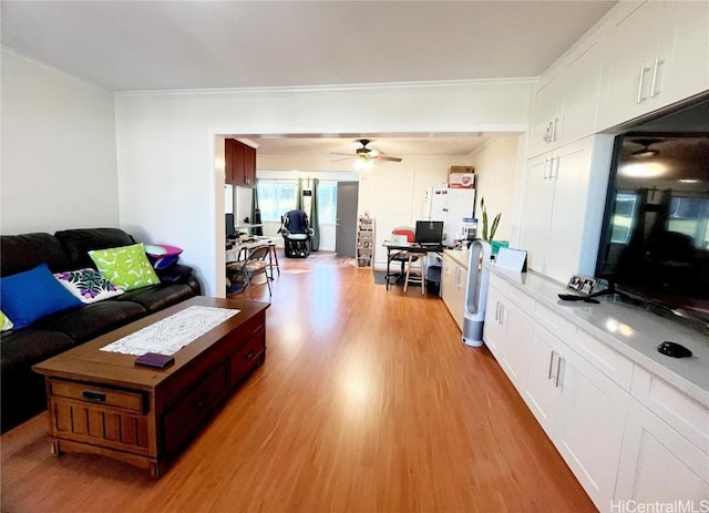 living room with ornamental molding, ceiling fan, and light wood-type flooring