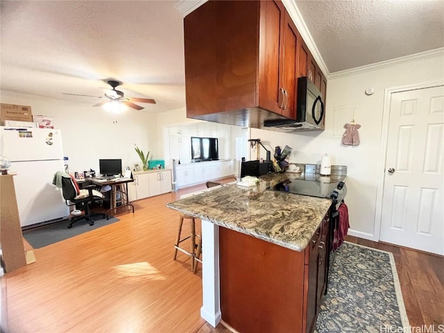 kitchen with hardwood / wood-style flooring, ornamental molding, black appliances, a textured ceiling, and stone countertops