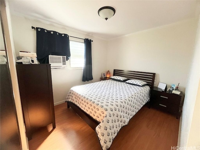 bedroom with cooling unit and hardwood / wood-style flooring