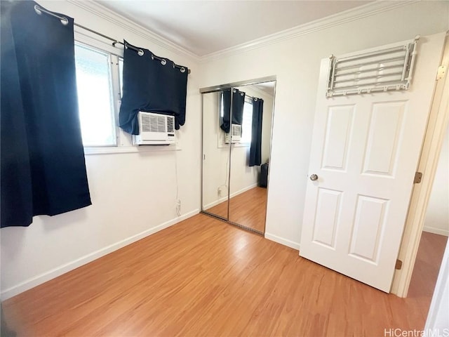 unfurnished bedroom featuring wood-type flooring, ornamental molding, cooling unit, and a closet