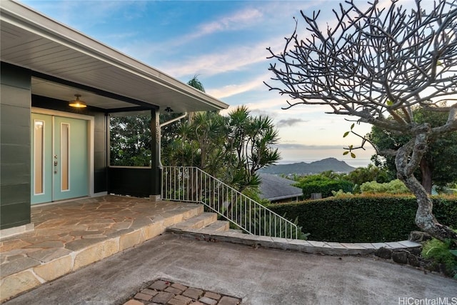 patio terrace at dusk with a mountain view and french doors